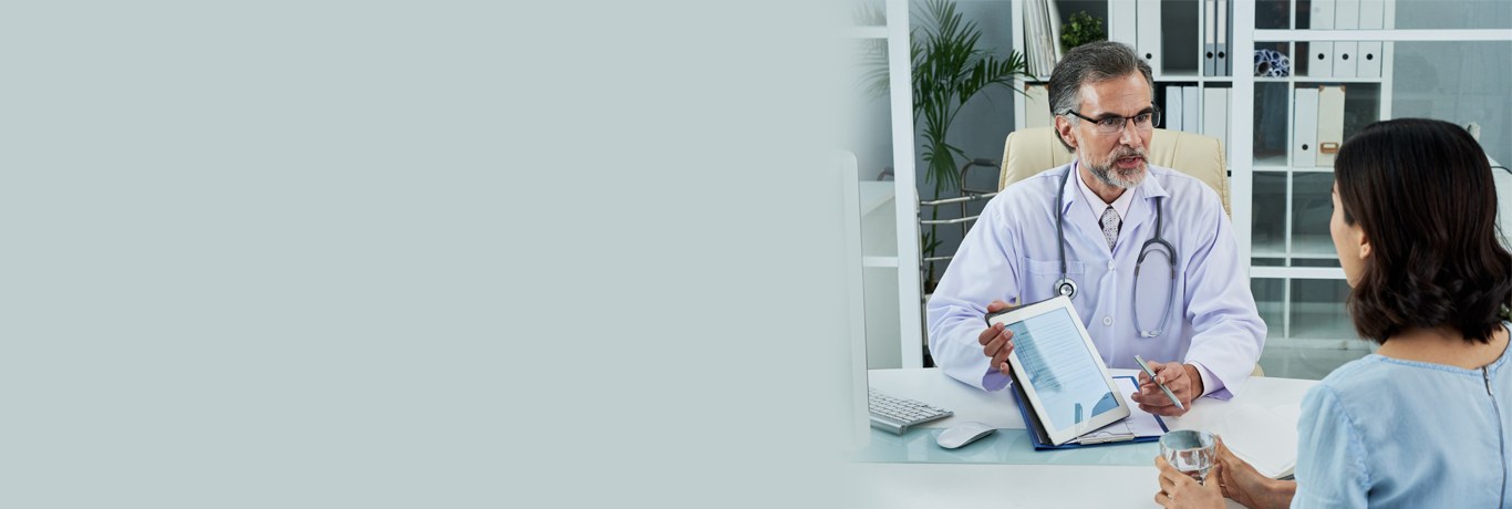A physician reviewing information with a patient during a consultation.